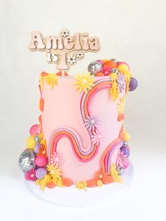 a pink birthday cake with flowers and decorations on top that says america is in the center