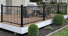 a deck with black railing and chairs on it