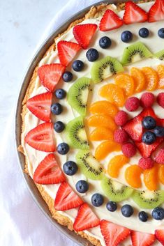 a pie topped with fresh fruit on top of a white table