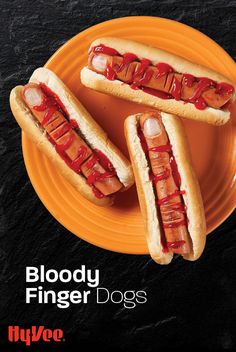 two hotdogs with ketchup and relish on them sitting on an orange plate