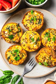 several muffins on a plate with spinach and strawberries in the background