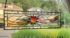 a large stained glass window hanging from the side of a building next to a street