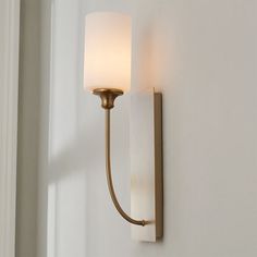 a wall light that is on the side of a white wall next to a window