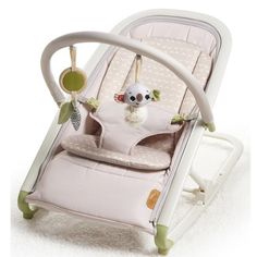 a baby's rocking chair with a stuffed animal in the back and on top