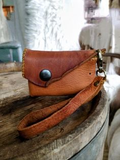 a brown purse sitting on top of a wooden barrel