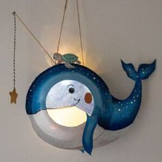 a light that is on the side of a wall with a whale hanging from it's side