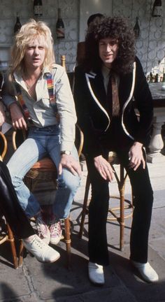 two people sitting on chairs in front of a building