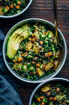 two bowls filled with vegetables and avocado on top of a wooden table