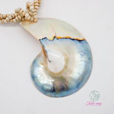 The White Nautilus shell is from the south of Thailand and partly from the Philippines and crafted in Indonesia. The Necklace is made of small white Racine beads and strung together with each bead to be a beading line and twisting each line to be one line for stronger and look beautiful, and it is 18 inches long, weight 45g. (including pendant) It's a real seashell from farming which it's fed by seaweed, not from the natural environment due to environmental conservation. Our product was crafted with craftsmanship from one generation to one generation, and it may not last forever. Unlike a product that is made by machine. It's not just an ordinary necklace but it's about the taste of the wearer. It's for you or anyone who infatuates nature and each of the shells may lookalike but not exactl Ocean-inspired Shell Beaded Necklaces With Round Beads, Ocean-inspired Colorful Beaded Shell Necklaces, Shell Beaded Necklaces For Jewelry Making, Ocean-inspired Beaded Shell With Round Beads, Ocean-inspired Beaded Shell Strand, Handmade Mother Of Pearl Shell, Beaded Shell Strand Necklace, Handmade White Abalone Shell, White Shell-shaped Beaded Necklace With Mother Of Pearl