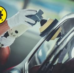 a man is waxing the side of a car with a yellow and black sticker