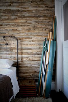 a bed sitting next to a wooden wall