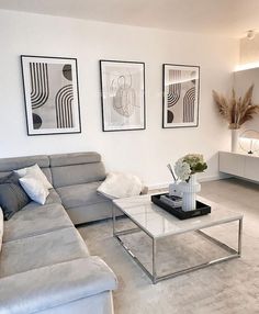 a living room filled with furniture and pictures on the wall above it's coffee table