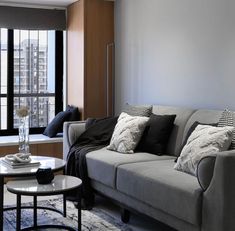 a living room filled with furniture next to a window covered in windowsills and curtains