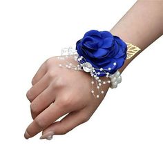 a woman's hand wearing a blue rose bracelet with pearls and beads on it