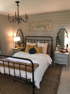 a bed with white sheets and pillows in a bedroom next to two lamps on either side of the bed