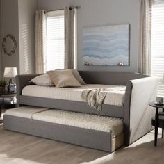 a daybed with a pull out trundle and pillows on it in a living room