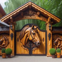 a horse head carved into the side of a wooden gate with two potted plants