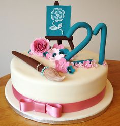 a decorated birthday cake sitting on top of a wooden table next to a blue sign