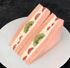 two pieces of cake on a plate with kiwi slices