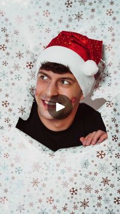 a man wearing a santa hat and holding a chocolate donut in front of his face