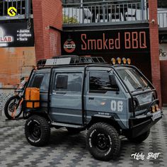 an suv parked in front of a building with smoked bbq written on it