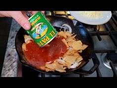 someone is adding seasoning to some food in a frying pan on the stove