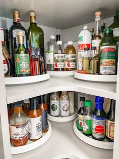 an open refrigerator filled with lots of bottles and condiments on top of shelves