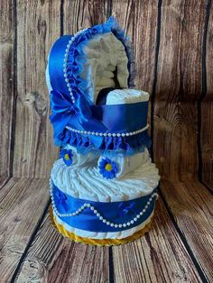 a blue and white diaper cake sitting on top of a wooden table