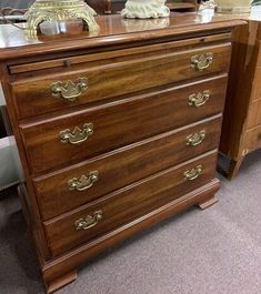 a wooden dresser with two vases on top of it next to other furniture items