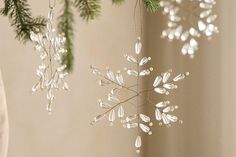 three ornaments hanging from a christmas tree in the shape of snowflakes and branches