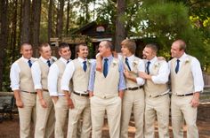 a group of young men standing next to each other in front of some pine trees