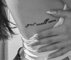 a woman's stomach with the word get well soon tattooed on her left side