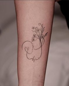 a woman's arm with a tattoo on it that has flowers growing out of it