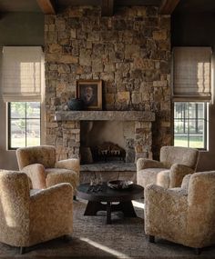 a living room with two chairs and a fire place in the middle of the room