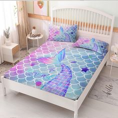 a bed with mermaid themed sheets and pillows