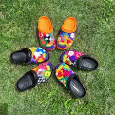 four pairs of colorful shoes sitting on top of the grass in front of each other