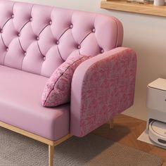 a pink couch sitting on top of a hard wood floor