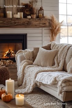 a living room filled with furniture and a fire place in front of a fireplace covered in blankets