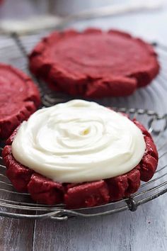 red velvet cookies with white frosting on a wire rack