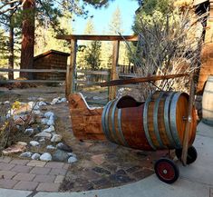 an old fashioned wooden barrel sitting in the middle of a yard