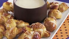 a white plate topped with croissants next to a cup of cream cheese