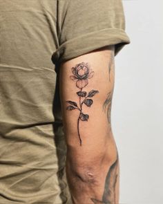 a man with a rose tattoo on his arm