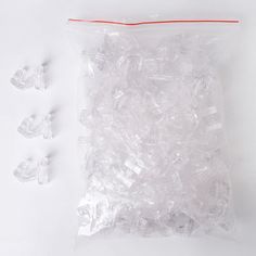 the plastic bag is filled with small pieces of clear glass beads and some red string