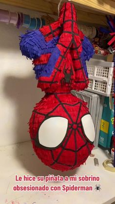 a spiderman pinata hanging from a shelf in a room with other items on the shelves