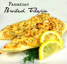 two pieces of fish with lemon wedges and parmesan bread