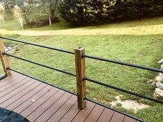 a wooden deck with black railing and green grass