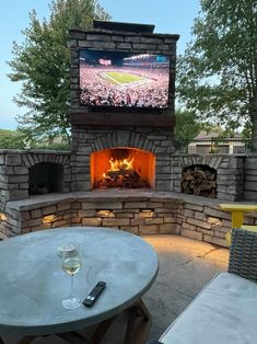 an outdoor fireplace with a big screen tv above it