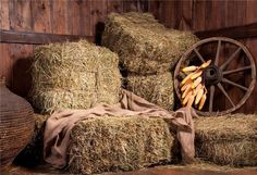 several bundles of hay stacked on top of each other in front of a wooden wall