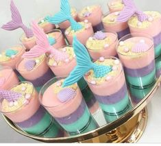 there are many desserts on the table with little mermaid decorations in them and under glassware