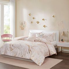 a bedroom with a bed, nightstands and window in the background that has gold foil decorations on it